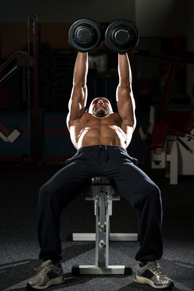 mature man doing dumbbell incline bench press workout