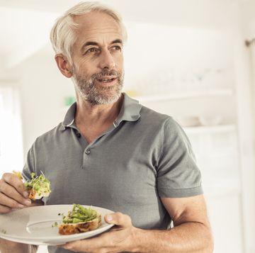 mature man eating a healthy avocado bread
