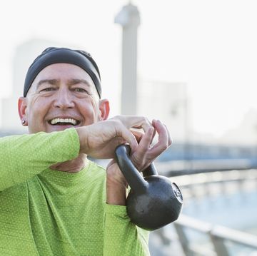 mature man in city, exercising with kettlebell