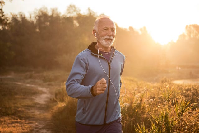 mature man jogging in by lake in morning time ,feeling young again