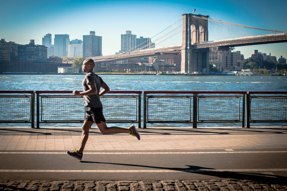 Mature man running along waterfront, New York, USA