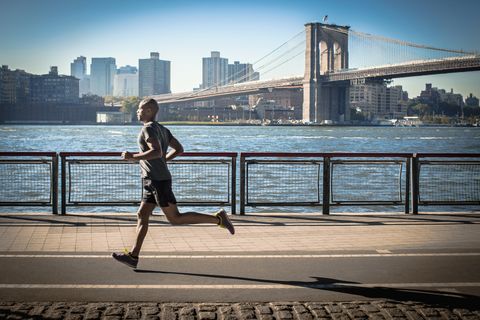 Mature man running along waterfront, New York, USA