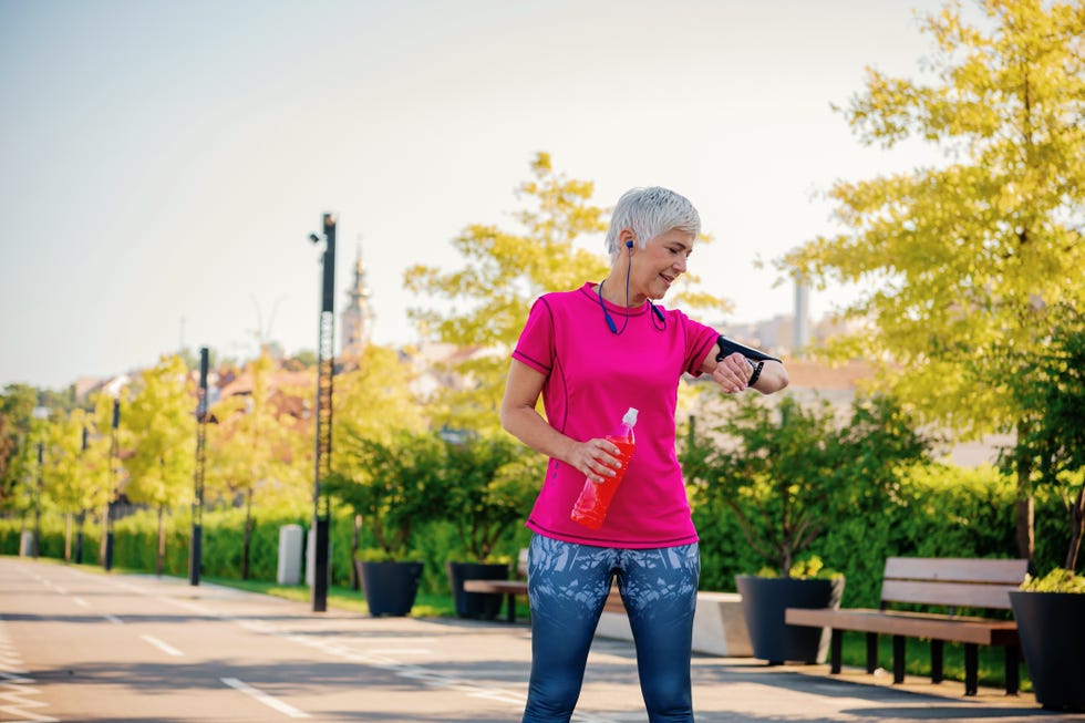 mature sport woman looking smart watch