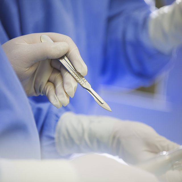 Mature surgeon using scalpel during surgery