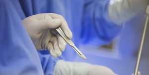 Mature surgeon using scalpel during surgery