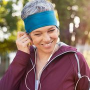 Mature woman adjusting earphones before running