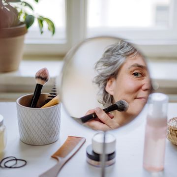 mature woman applying a make up at home