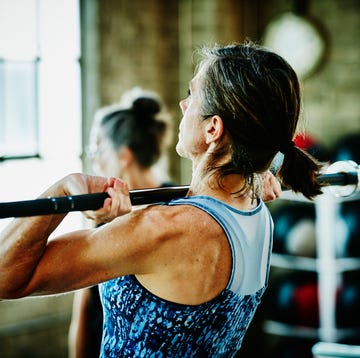 mature woman doing barbell lifts during workout