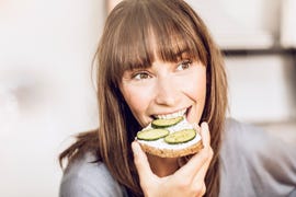 mature woman eating healthy cucumber bread