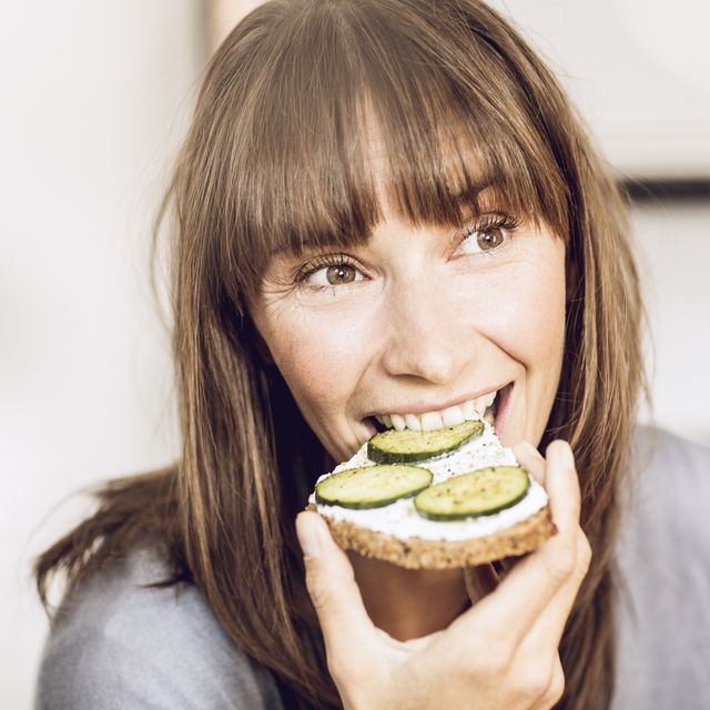 mature woman eating healthy cucumber bread