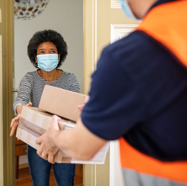 mature woman getting package from delivery person during pandemic