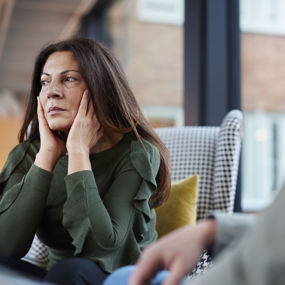 mature woman holding head in hands