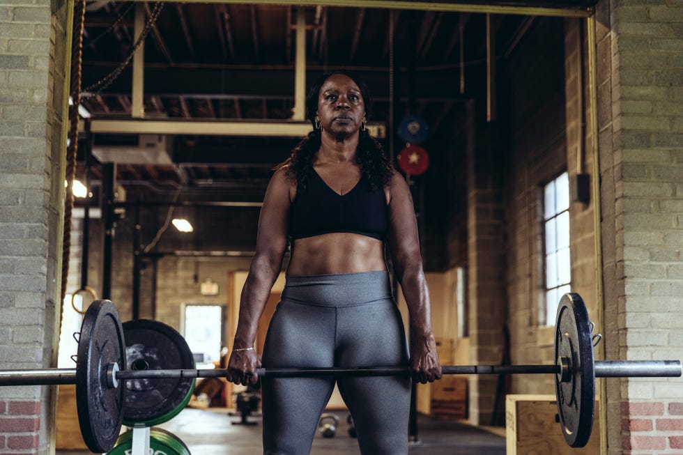 mature woman lifting weights at gym