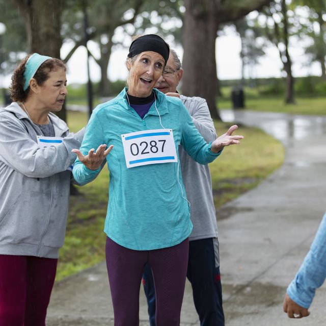 mature woman preparing to run race, talking to friend