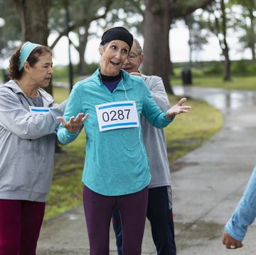 mature woman preparing to run race, talking to friend