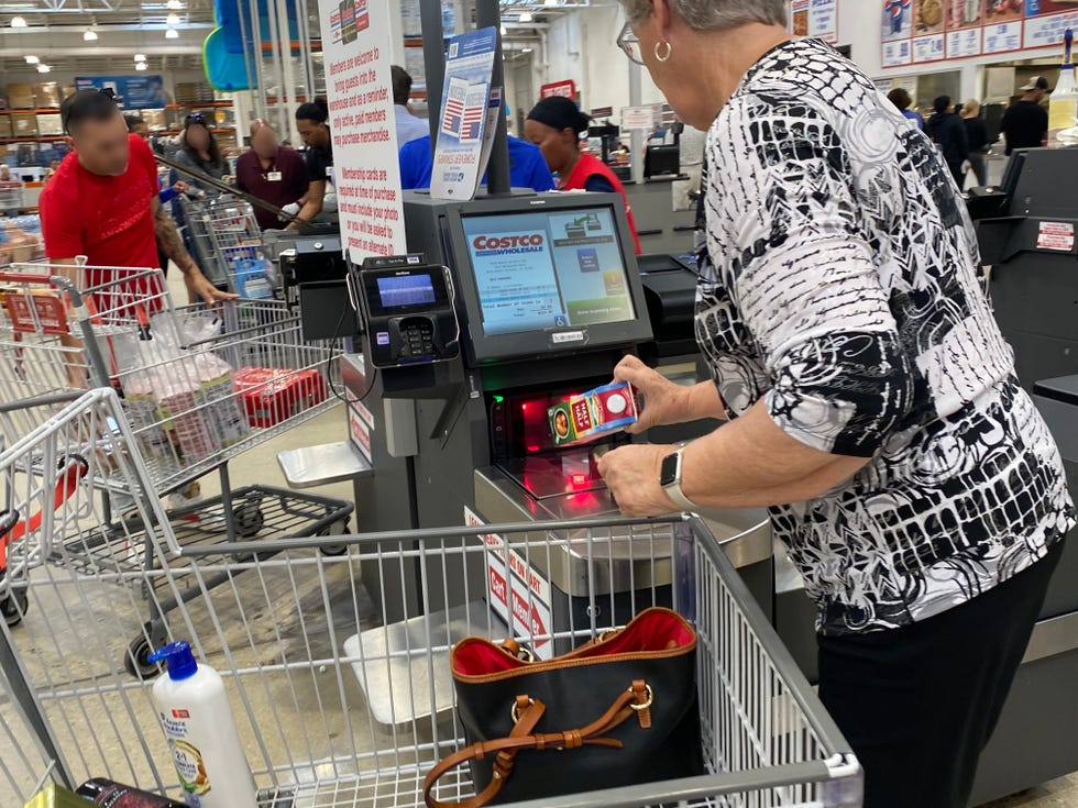 Mature woman scanning groceries at self-checkout lane at Costco, Palm Beach, Florida