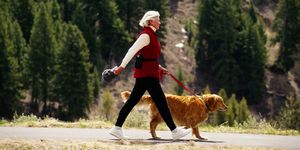 mature woman walking golden retriever dog