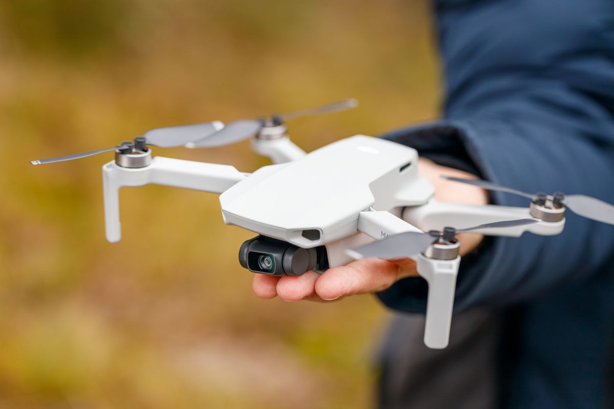 dji mavic mini drone quadcopter in hand man close up