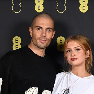 max george and maisie smith, a couple stand looking at the camera slightly smiling and wearing casual tshirts
