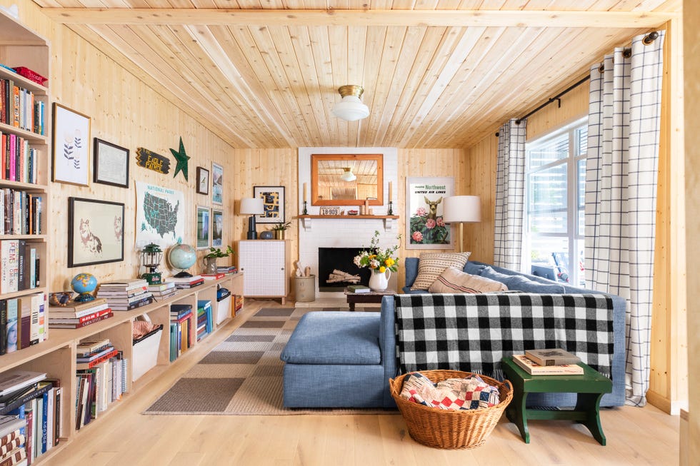 wood paneled living room with blue sectional sofa and wall of bookcases