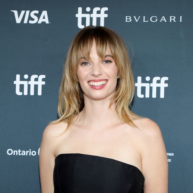 maya hawke smiles at the camera, she wears a black strapless gown