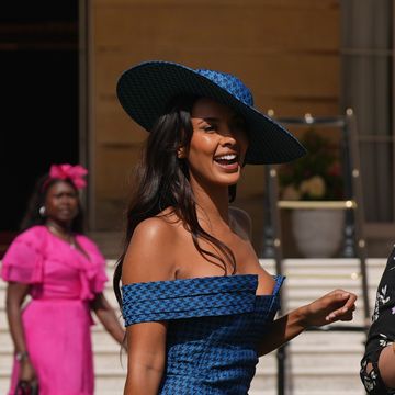 maya jama wears a blue hat and dress at buckingham palace