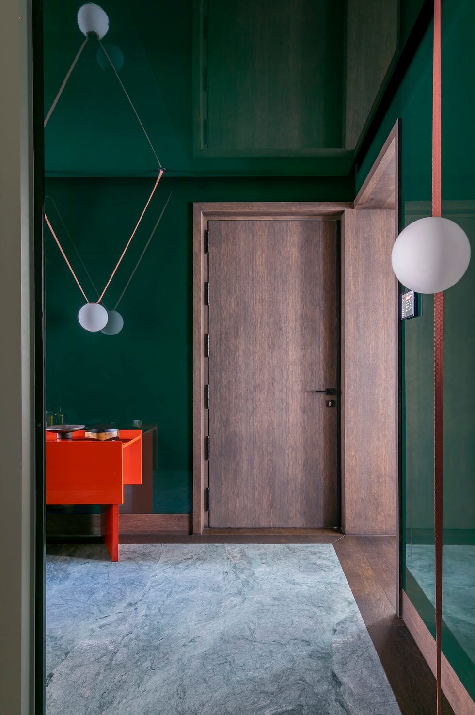 recibidor con puerta de madera y consola roja