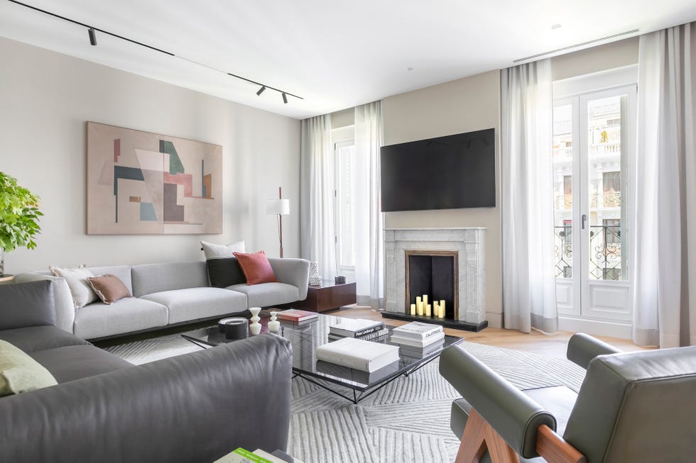 salón con chimenea, muebles de diseño y cuadro en la pared