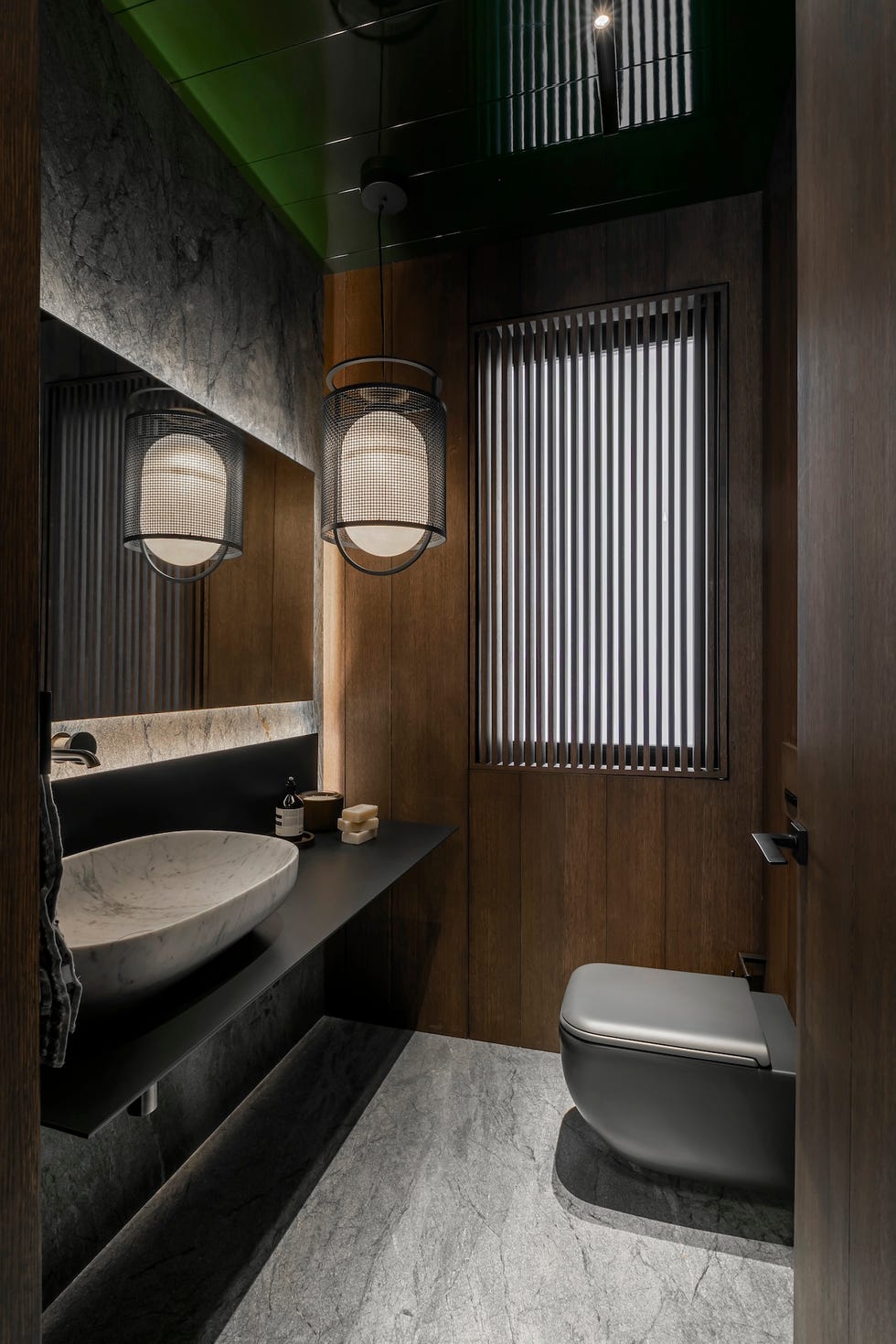 baño con revestimiento de pierda y madera y lavabo volado