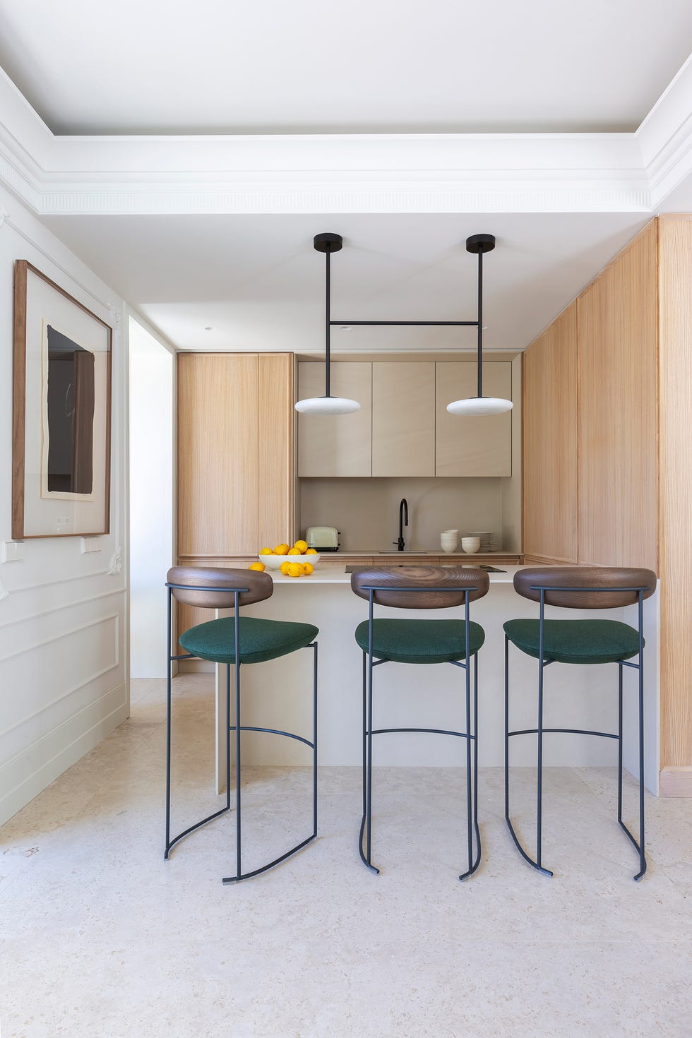 cocina con muebles de madera, península y taburetes