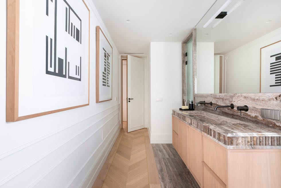baño con molduras blancas y mueble de madera volado