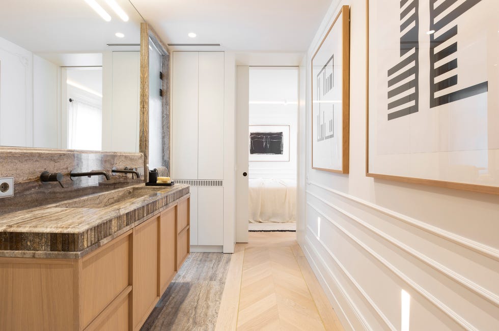 baño con molduras blancas y mueble volado de madera