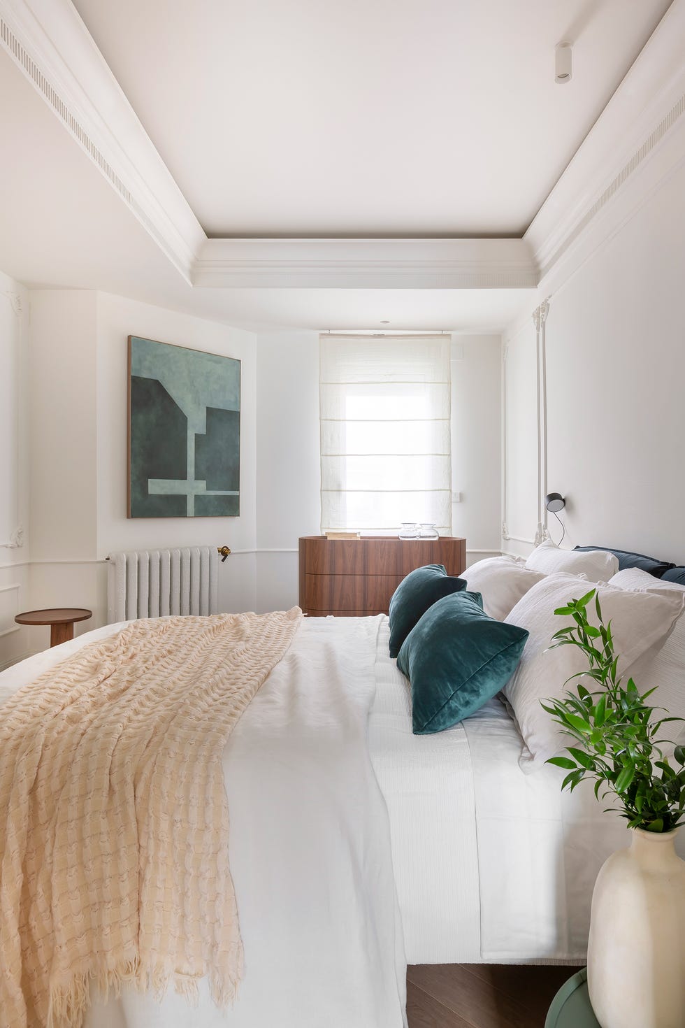 dormitorio con molduras blancas clásicas y cómoda de madera
