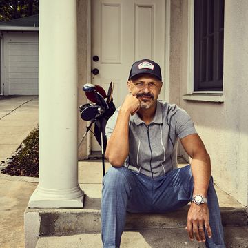 maz jobrani sitting on a step with golf clubs in backgrouns