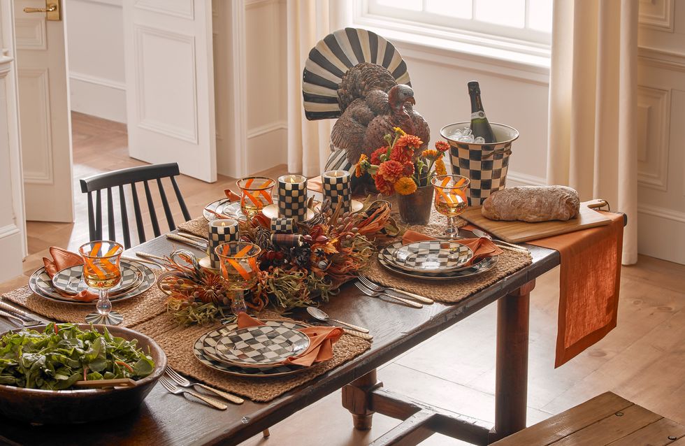 a table set with mackenzie child plates and a decorative turkey
