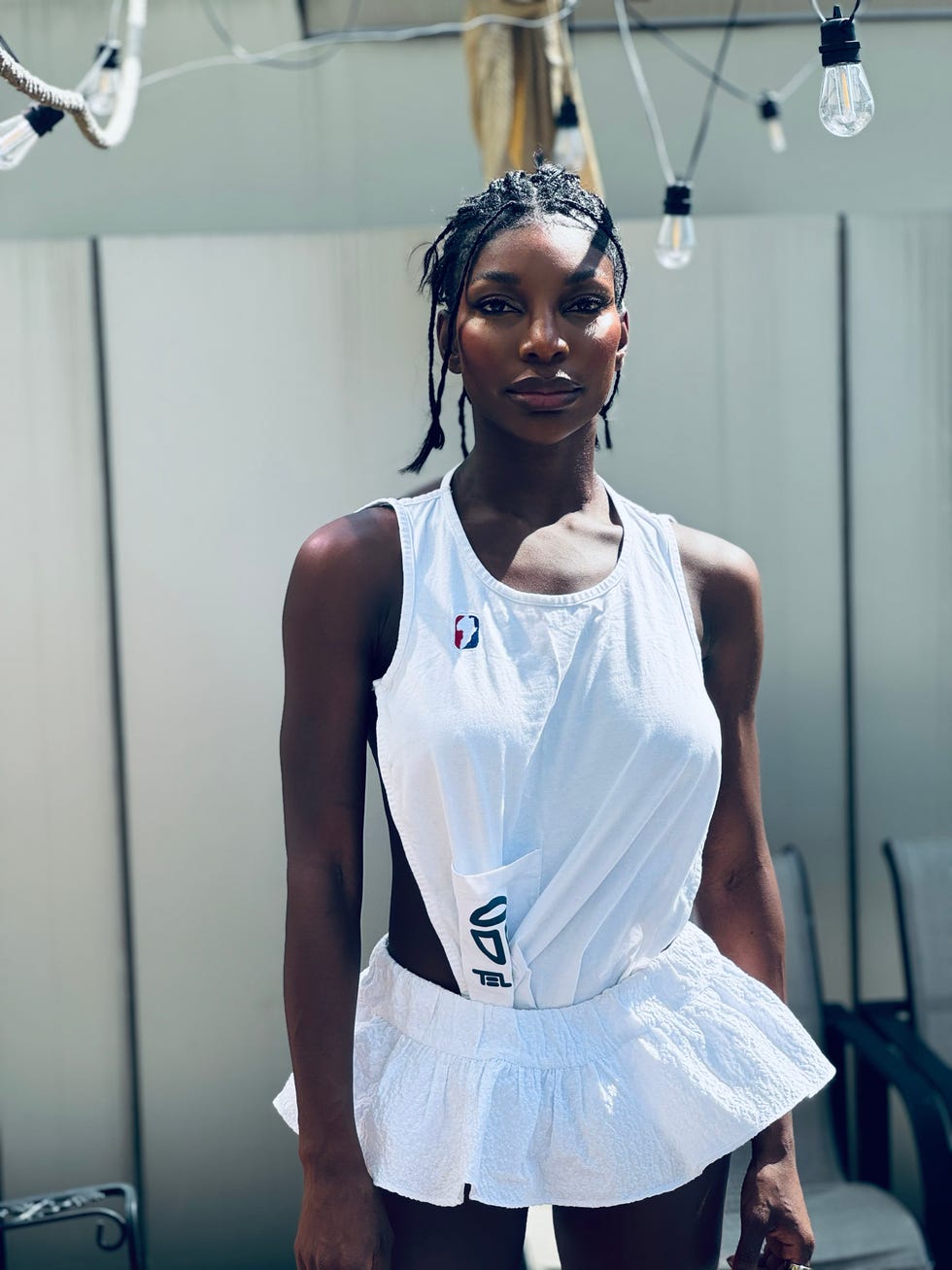 person wearing a white sleeveless outfit with a flared bottom