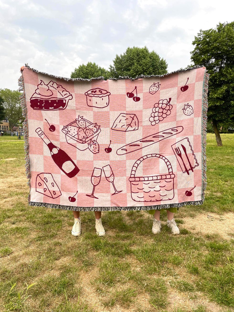 a picnic blanket featuring various food and drink illustrations