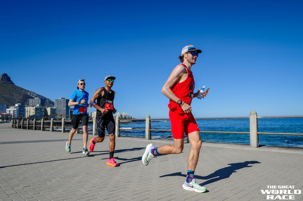 three runners during a race along a path by the ocean