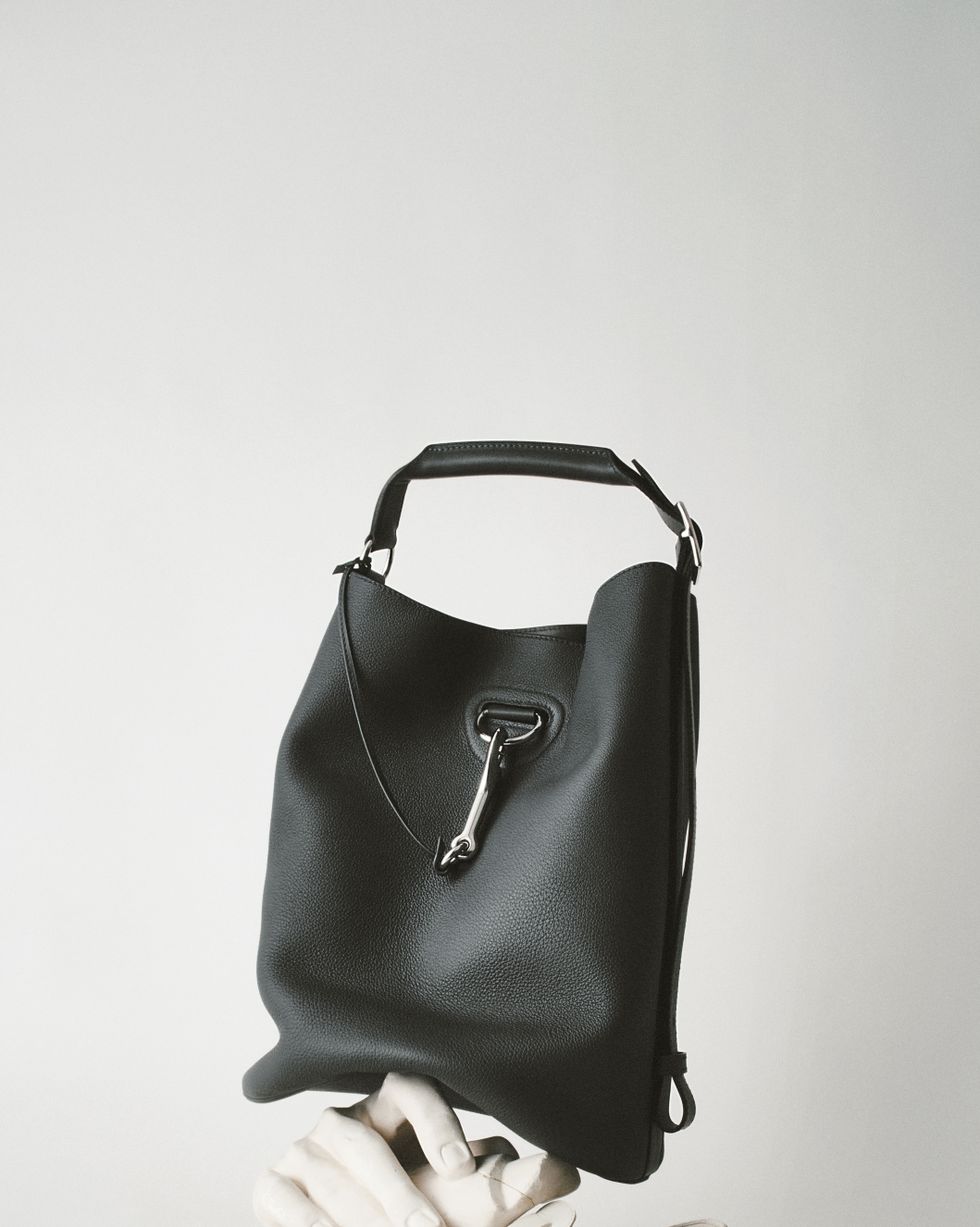 a black purse with a white glove