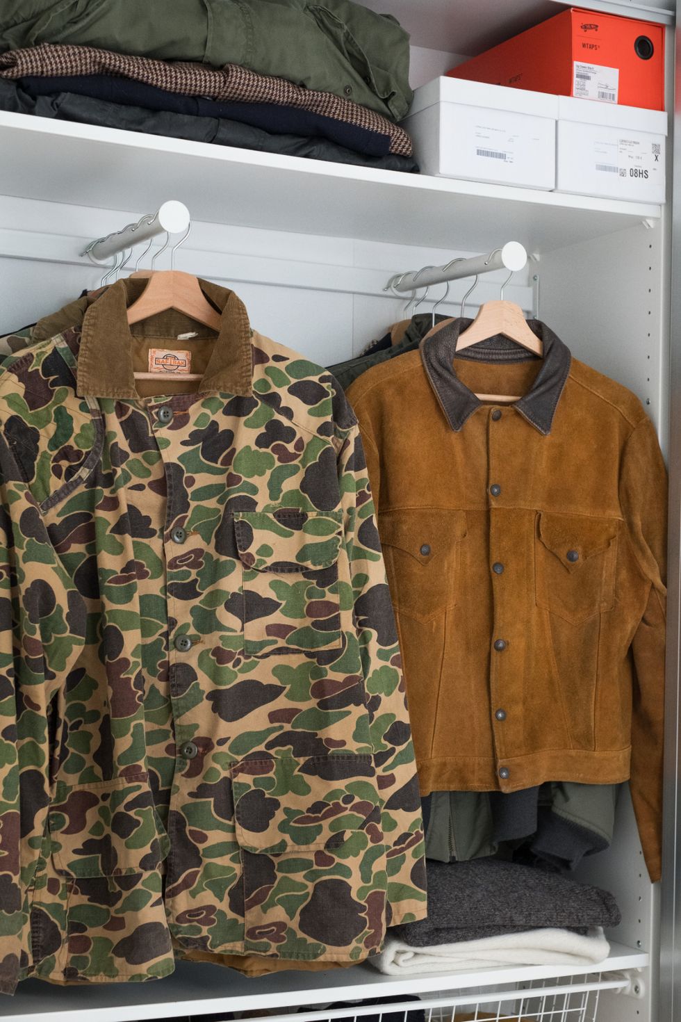 a pair of brown and black jackets on a shelf