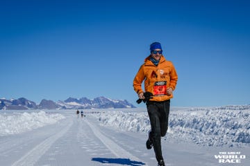 a runner wearing cold weather clothing running on a snowy road