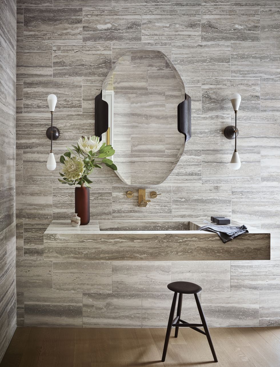 in the powder room, travertine stone extends to a floating custom sink