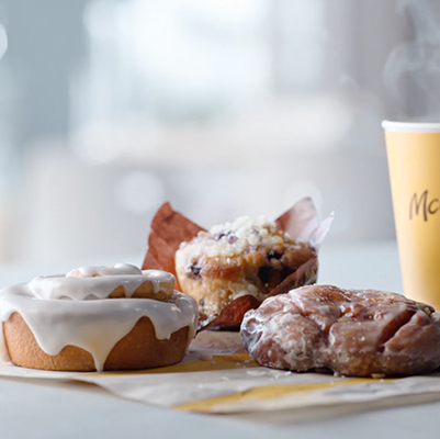 mcdonald's bakery items including a cinnamon roll, blueberry muffin, and apple fritter with coffee