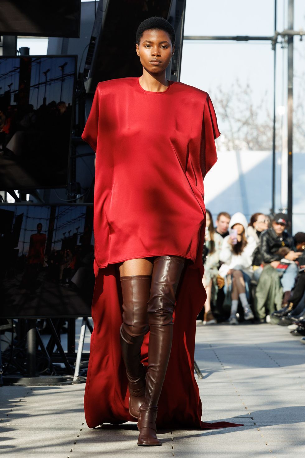 a man wearing a red dress and boots