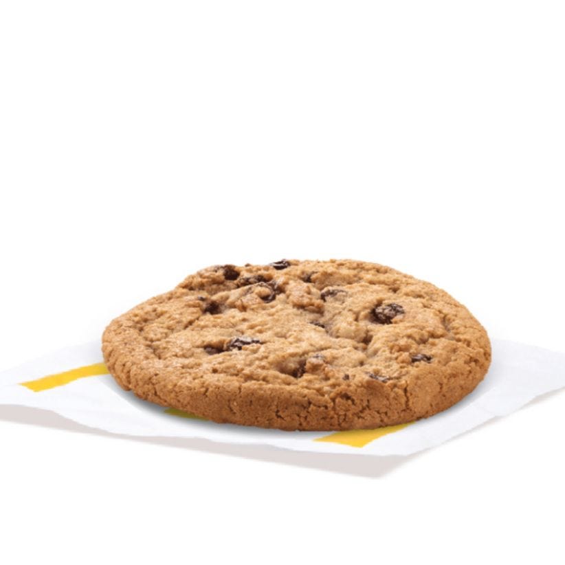 chocolate chip cookie resting on a piece of paper