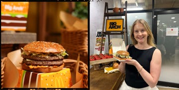 a person holding a large burger in a food event setting