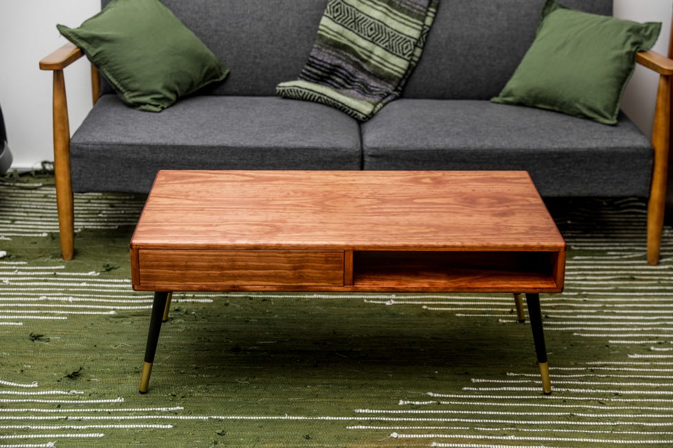 mesa de centro de madera con cajón de almacenamiento frente a un sofá gris