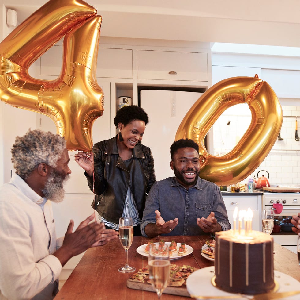meaningful birthday wishes for best friend smiling woman holding number 40 helium balloons while standing by man during birthday party with family at home