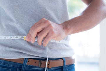 man measuring waist