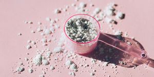measuring spoon with collagen powder or alginate mask on pink background